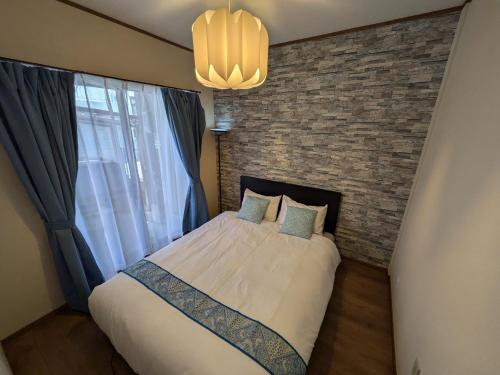 a bedroom with a bed and a brick wall at Villa Castle Ginza ヴィラ キャッスル 銀座 in Hikone