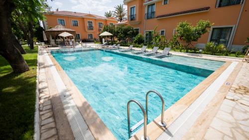 a large swimming pool with chairs and a building at Ema Houses in Antalya