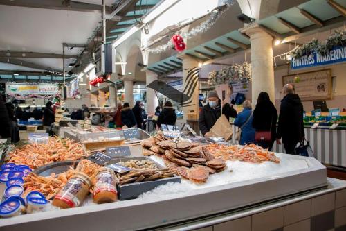 des personnes se promenant autour d'un marché avec des fruits de mer exposés dans l'établissement Maëlle - Studio situé en plein centre-ville, à Rochefort