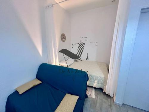 une chambre avec un canapé bleu et un lit dans l'établissement Maëlle - Studio situé en plein centre-ville, à Rochefort