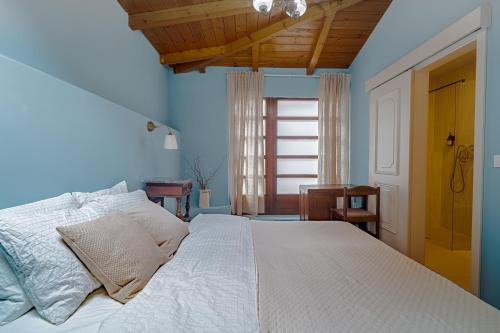une chambre avec un grand lit blanc avec des murs bleus dans l'établissement Upper Town Rooms, à Zagreb