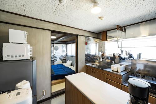 a kitchen with a sink and a refrigerator at Holiday cottage BEPPU ICHIYA in Beppu