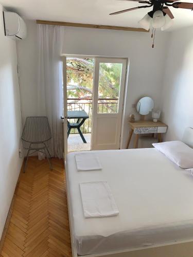 a bedroom with a bed and a door to a patio at Villa Sanja in Mimice