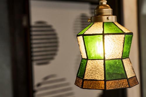 a green lamp hanging from a wall at Holiday cottage BEPPU ICHIYA in Beppu