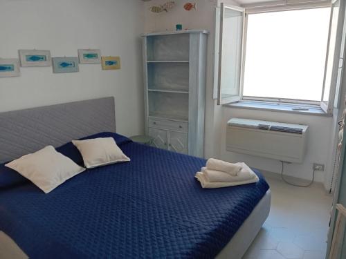 a bedroom with a blue bed with two towels on it at La Perla in piazza Duomo a Pietrasanta in Pietrasanta