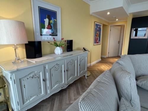 a living room with a couch and a dresser at Queen-Josefine Meerblick-Ecksuite in Lübeck