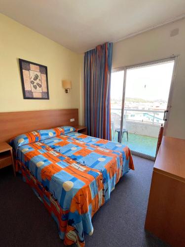 a hotel room with a bed and a large window at Hotel Natura Park in Comarruga