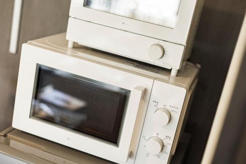 two microwaves sitting on top of a microwave at Holiday cottage BEPPU ICHIYA in Beppu
