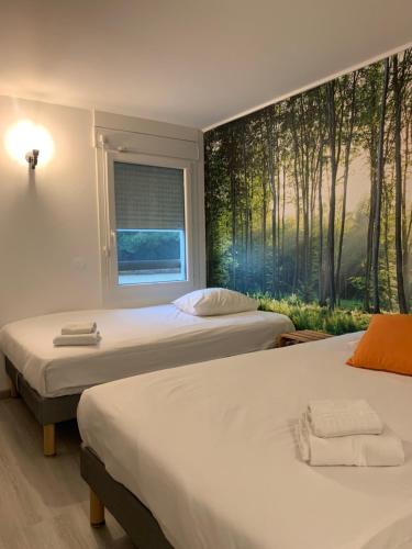 two beds in a room with a mural of trees at Urban Style Arl HOTEL in Arles