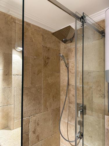 a shower with a glass door in a bathroom at Apartmani Vila Zabljak in Žabljak