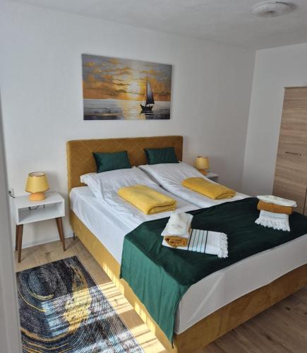 a bedroom with a large bed and a sailboat on the wall at Mahala Apartments in Visoko