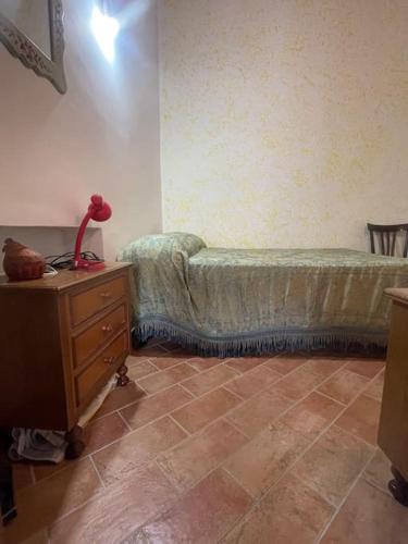 a bedroom with a bed and a dresser with a lamp at Casa in montagna per vacanze in tranquillità in Fagge