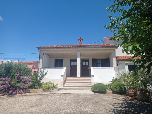 una casa blanca con una entrada delante de ella en Apartment Studio Antonia, en Medulin