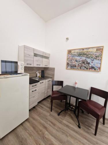 a kitchen with a table and chairs and a refrigerator at Apartman 4 YOU 2. in Budapest