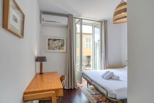 une chambre avec un lit, une table et une fenêtre dans l'établissement S3 Suite Bonaparte 5 min to Old Town Balcony & AC, à Nice