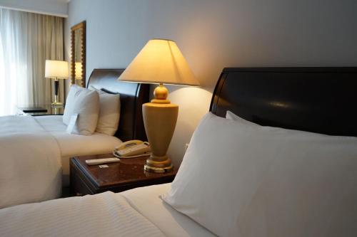 a hotel room with two beds and a lamp on a table at JW Marriott Caracas in Caracas