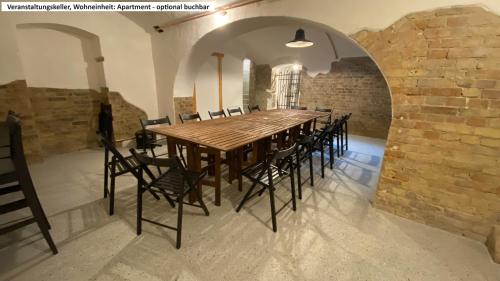 a long table and chairs in a room with a brick wall at Blaue Perle Templin in Templin