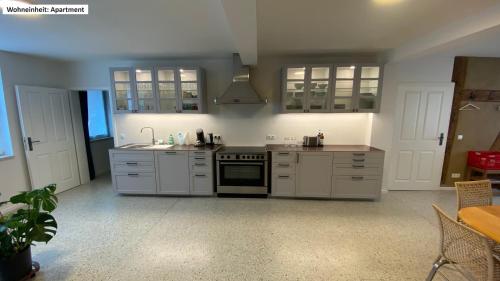 a kitchen with white cabinets and a stove at Blaue Perle Templin in Templin