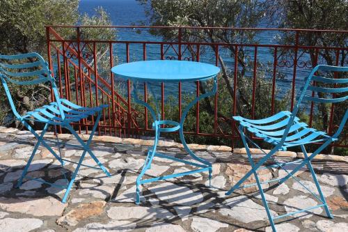 two chairs and a table and two tables and chairs at Δωμάτια Κόκκινος Πύργος in Plomarion