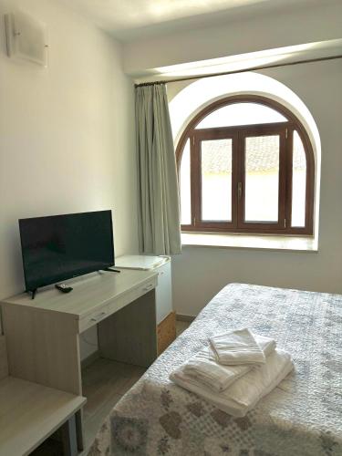 a bedroom with a bed and a desk with a computer at Il Veliero in Marzamemi