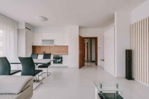 a living room with a table and chairs and a kitchen at BIRGÉS Villapark Apartments in Balatonfüred