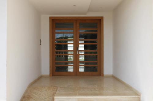 a wooden door in a room with white walls at Très Joli rez-de-jardin à 2 min de la plage Les Sablettes in Mohammedia