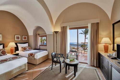 a hotel room with two beds and a view of the ocean at Steigenberger Coraya Beach - Adults Friendly 16 Years Plus in Coraya Bay