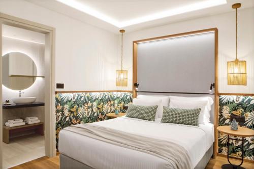a bedroom with a large bed and a sink at Mirabello Bay Luxury Resort in Agios Nikolaos