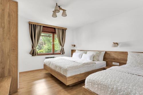 a bedroom with two beds and a window at Apartments Svetina in Bled