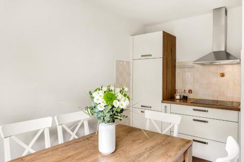 a kitchen with a wooden table with a vase of flowers at Apartments Svetina in Bled