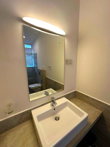 a bathroom with a sink and a large mirror at Flaming Tree Resorts in Kiriwan Eliya