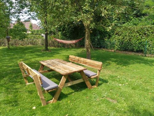a wooden picnic table and a bench in the grass at The Two Oaks - Private garden for guests in Hertsberge