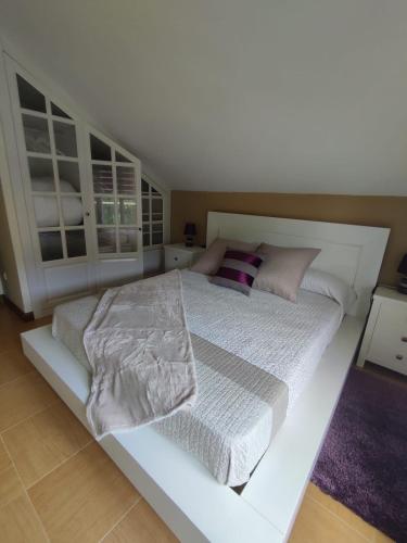 a white bedroom with a large white bed with pillows at Tejas verdes in Argoños