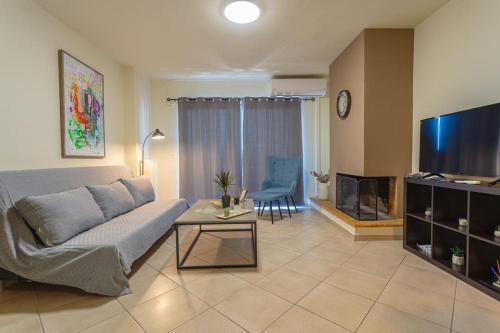 a living room with a couch and a tv at Urban Breeze Chalkida in Chalkida