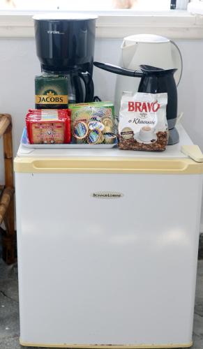 a shelf with food on top of a coffee maker at Δωμάτια Κόκκινος Πύργος in Plomarion