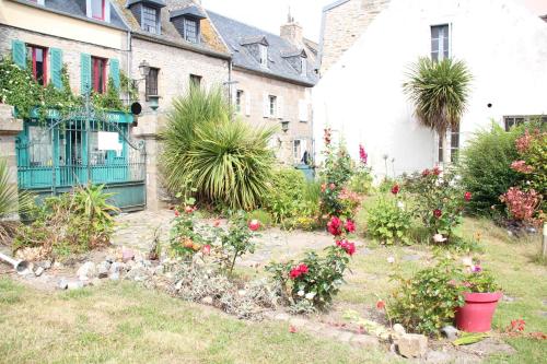 a garden in front of a house with flowers at L'Appartement du port, vue mer, jardin et parking in Roscoff