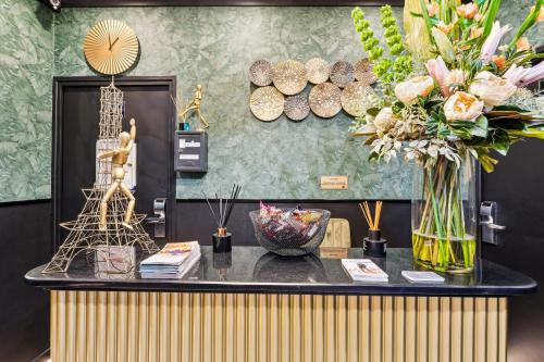 a table with a vase of flowers on top of it at Résidence AURMAT - Appart - Hôtel - Boulogne - Paris in Boulogne-Billancourt