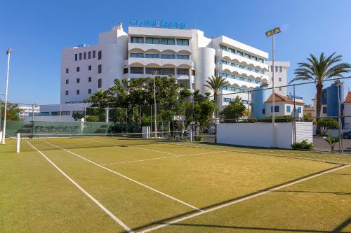 a tennis court in front of a building at Crystal Springs Beach Hotel in Protaras