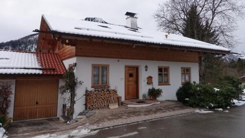 a small house with snow on top of it at Landhaus am Bergfeld in Bayrischzell