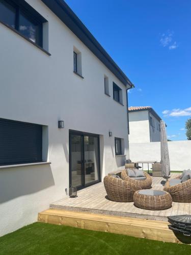 un patio avec deux chaises en osier et un patio avec dans l'établissement Villa Jasmine, à Garons