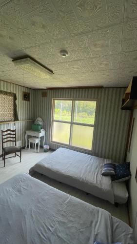 a bedroom with a bed and a couch and a window at Sound Garden Biei - Forest suite in Biei