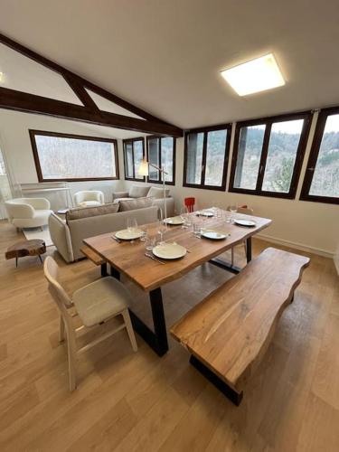 a living room with a table and a couch at Appartement Le Romy Vue Montagne in Mont-Dore