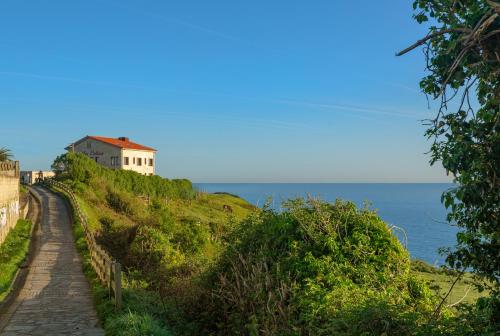 a house on a hill next to the ocean at La Colina in Gijón