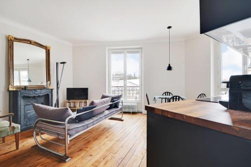 un salon avec un canapé et une cheminée dans l'établissement GuestReady - Parisian elegance in the 19th Arr., à Paris