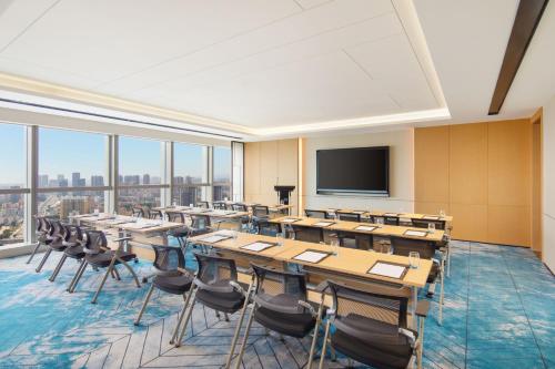a conference room with tables and chairs and a flat screen tv at Fairfield by Marriott Shenzhen Bao'an in Shenzhen