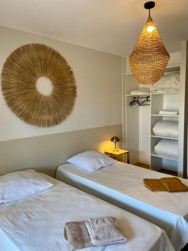 Ce lit se trouve dans un dortoir doté d'un ventilateur mural. dans l'établissement Vue Océan - Au Coeur de Contis Plage, à Saint-Julien-en-Born