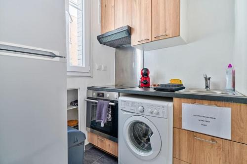 une cuisine avec une machine à laver et un évier dans l'établissement Melanie house, à Saint-Ouen