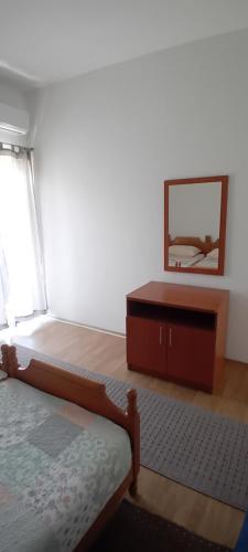 a bedroom with a bed and a dresser and a mirror at Apartmani AnĐela in Neum