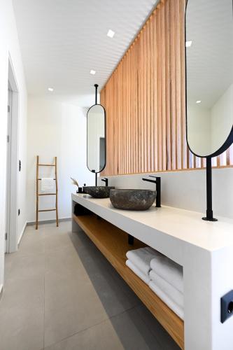 a bathroom with a vanity with a mirror and towels at Etherial View Villas Skiathos in Skiathos