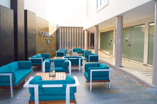 a row of blue chairs and tables in a building at Hotel CasaBlanca Cucuta in Cúcuta